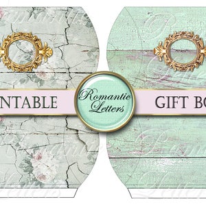 May include: Printable gift box template featuring two designs: one with a cracked, light blue woodgrain background and floral accents, and the other with a solid light blue woodgrain background. Both designs include a gold ornate frame with a circular opening.