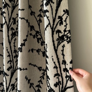 May include: A curtain panel featuring a textured off-white fabric base with a prominent black branch and twig pattern. The design consists of vertical, sprawling lines that mimic natural tree growth, creating a high-contrast visual effect.