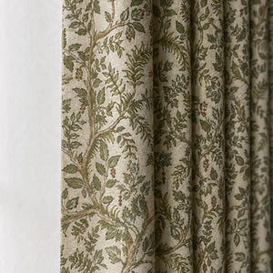 May include: A pleated curtain panel featuring a light beige background with a repeating botanical pattern of brown tree branches, green leaves, and small clusters of red berries. The fabric has a textured appearance with vertical folds.