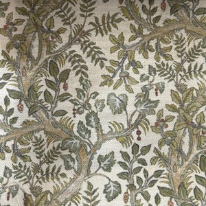 May include: A woven fabric featuring a dense botanical pattern of intertwining tree branches, textured leaves in shades of olive and sage green, and small red berries set against a light cream-colored background with a visible textile weave.