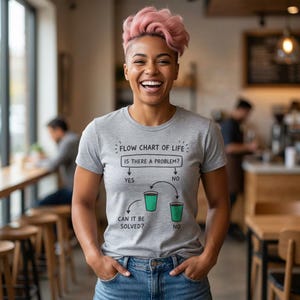 May include: A heather grey t-shirt featuring a black graphic flow chart titled Flow Chart of Life. The chart asks Is There A Problem? with Yes and No branches, leading to illustrations of two green coffee cups and the text Can It Be Solved?