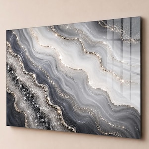 May include: A rectangular wall art piece featuring an abstract design of flowing, wavy layers in shades of charcoal, slate grey, and white. The composition includes textured, crystalline accents and thin, shimmering gold lines that follow the curves.
