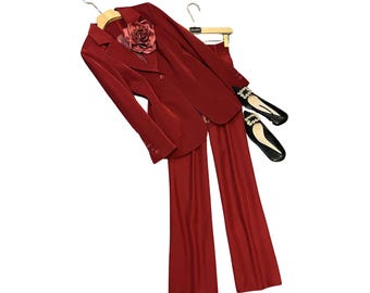 Conjunto elegante de calça e blazer vermelhos com broche de flor.