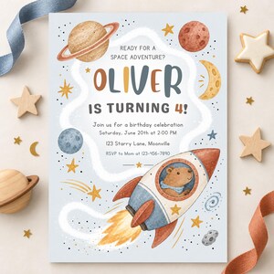May include: A rectangular birthday invitation card featuring a space theme with a rocket ship, a bear pilot, planets, stars, and the text: READY FOR A SPACE ADVENTURE? OLIVER IS TURNING 4! Join us for a birthday celebration Saturday, June 20th at 2:00 PM, 123 Starry Lane, Moonville, RSVP to Mom at 123-456-7890.