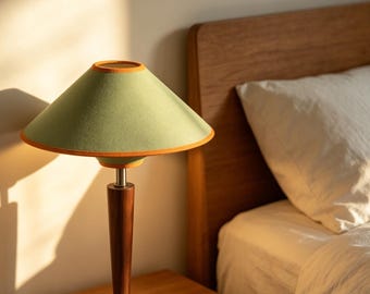 Lámpara de mesa de estilo moderno de mediados de siglo, con pie de madera y pantalla de lino, ideal para crear un ambiente acogedor junto a la cama.