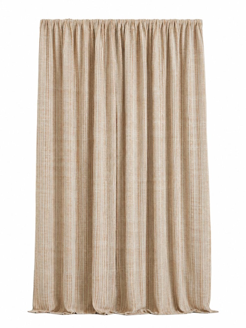 May include: A floor-length curtain panel featuring a vertical striped pattern in shades of beige, tan, and cream. The fabric has a visible woven texture and is gathered at the top with a rod pocket header, creating uniform vertical folds throughout.