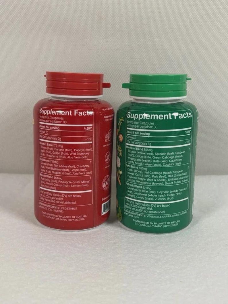 May include: Two supplement bottles with red and green lids. The red bottle has a label with supplement facts and ingredients, including fruit blends. The green bottle also has supplement facts and ingredients, including vegetable blends.