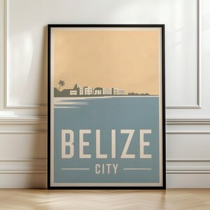 May include: A rectangular wall art print in a black frame featuring a stylized graphic of the Belize City skyline. The design displays a beige sky above a blue sea, with the text BELIZE CITY printed in large, bold, light-colored capital letters.