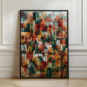May include: A framed vertical wall art print depicting a dense, layered townscape with numerous buildings, church towers, and trees in a palette of deep reds, oranges, greens, and browns, showcasing an autumn-inspired architectural scene.
