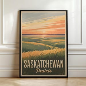 Może przedstawiać: Oprawiony pionowy plakat przedstawiający stylizowaną ilustrację krajobrazu prerii Saskatchewan o zachodzie słońca. Grafika ukazuje faliste zielone i złote pola pod pomarańczowo-różowym niebem, z napisem Saskatchewan Prairie.