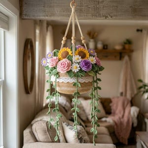 May include: A hanging crochet basket filled with colorful crochet flowers, including sunflowers, roses, and daisies. The basket is suspended by a macrame hanger with wooden beads. Green crochet vines cascade down, adding a touch of nature to the decor.