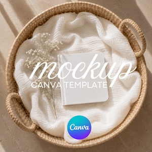 May include: A white notebook sits on a cream-coloured cloth within a woven basket. The words "mockup" and "CANVA TEMPLATE" are visible. A sprig of delicate white flowers adds a natural touch. A Canva logo is in the bottom right.
