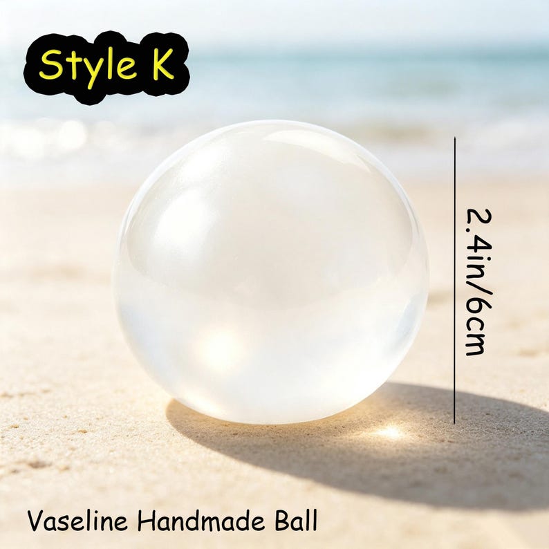May include: A clear, spherical Vaseline handmade ball labeled Style K. The object is translucent with a smooth surface and measures 2.4 inches in diameter. The text Style K and Vaseline Handmade Ball are visible in the image.