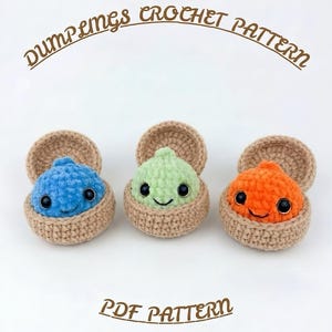 May include: Three crocheted dumplings in tan baskets, one blue, one light green, and one orange, each with black safety eyes and a stitched smile. The text DUMPLINGS CROCHET PATTERN and PDF PATTERN appears in brown lettering above and below the items.
