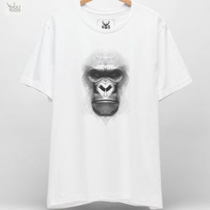 A premium gorilla graphic tee in white featuring a highly detailed optical illusion illustration of a silverback ape composed entirely of sweeping black lines, centered on the chest. This king kong t-shirt line art silhouette by HolyDeer perfectly captures the hypnotic gorilla top energy for all styles.