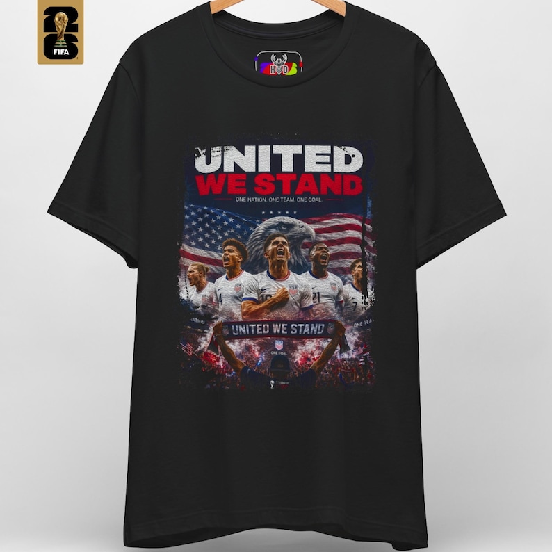A premium United We Stand shirt in black featuring an patriotic illustration of USA soccer players, a bald eagle, and the American flag. This USA World Cup 2026 soccer tee by HolyDeer perfectly captures the USMNT pride and FIFA 2026 apparel aesthetic.