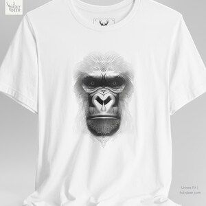 Lifestyle photograph of the gorilla graphic tee against a neutral concrete backdrop to highlight the pure white cotton tone and the high-contrast linear ape graphic. This piece by HolyDeer serves as a unique gift for abstract wildlife art lovers.