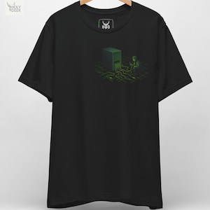 May include: Black t-shirt featuring a green and black graphic of a person interacting with a digital cube, with green lines extending from it. The shirt has a crew neck and short sleeves. The brand logo "H D" is visible on the upper chest.