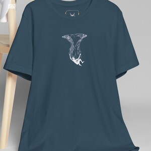 A person wearing a deep ocean tee in deep teal with a sharp, emotional underwater graphic on the front. The shirt represents a sophisticated philosophical lifestyle and is part of the HolyDeer collection, designed for those who appreciate abstract floating tops.