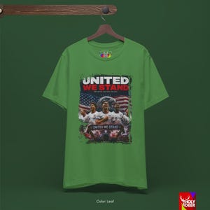 An artistic representation of the United We Stand shirt displayed on a minimalist hanger. The black color and detailed soccer art by HolyDeer create an emotional trigger for those seeking exclusive world cup gifts.