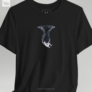 A lifestyle image of the deep ocean tee paired with minimal metallic jewelry and modern lifestyle accessories to suggest a complete contemporary streetwear lifestyle. HolyDeer creates a visual story that makes this unique artist gift a necessary addition.