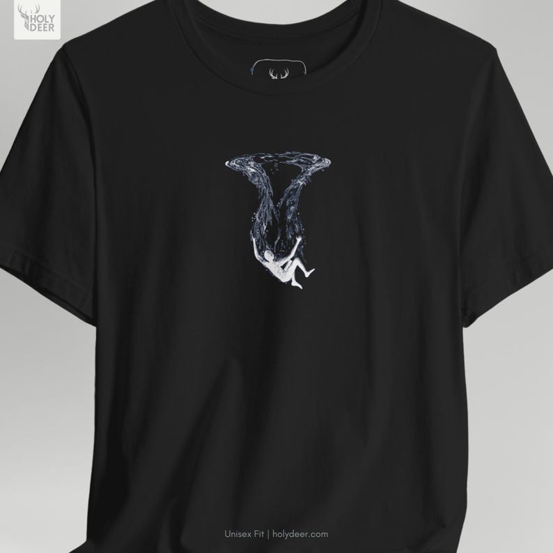 A lifestyle image of the deep ocean tee paired with minimal metallic jewelry and modern lifestyle accessories to suggest a complete contemporary streetwear lifestyle. HolyDeer creates a visual story that makes this unique artist gift a necessary addition.