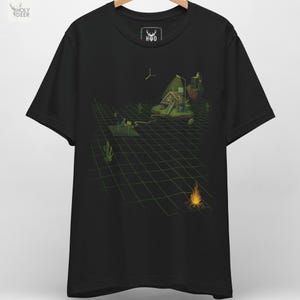 May include: Black t-shirt featuring a surreal graphic design. The design depicts a grid-like landscape with a small house, a campfire, and a person working on a laptop. The shirt has the "H D" logo on the collar.