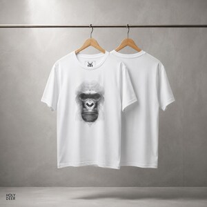 Close up detail of the hypnotic gorilla design on a soft white fabric showcasing the fine monochrome vector line work, the incredible depth around the eyes, and the rhythmic flow of the geometric fur patterns. This optical illusion art apparel from HolyDeer is a true digital masterpiece.