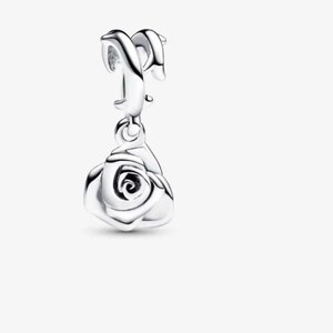May include: A polished silver charm featuring a dangling rose pendant. The charm has a curved, smooth bail at the top designed for attachment to a bracelet or necklace chain, with a detailed, layered rose flower shape hanging below it.