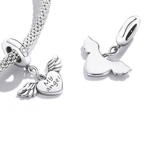 May include: Silver charm bracelet with two angel-themed charms. One charm is a heart with the words "My angel" and wings. The other charm is an angel silhouette. The bracelet has a textured, woven design.