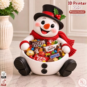 May include: A white snowman-shaped bowl with black buttons, a black top hat with holly, and a red scarf, filled with assorted candy bars including M&Ms, Kinder Bueno, Snickers, and KitKat. Text reads 3D Printer Files, Instant Download.