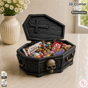May include: A black coffin-shaped box with a hinged lid featuring a cross, a skull relief on the front, and spiderweb carvings on the sides. The box is filled with various colorful candies, including Kinder Bueno, KitKat, and Snickers bars.