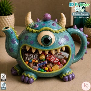 Può includere: Una teiera a forma di mostro color verde acqua con macchie viola, un unico grande occhio e una bocca spalancata piena di vari cioccolatini. La creatura in stile ceramica presenta due corna, un coperchio, un beccuccio e un manico, con il testo 3D Printer Files, Instant Download e STL + 3MF Included.