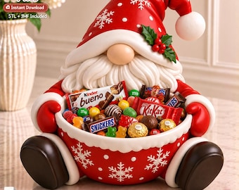 May include: A red and white Santa gnome figurine holding a bowl filled with assorted sweets including Kinder Bueno, KitKat, and Snickers bars. The gnome wears a red hat with white snowflakes and a white pom-pom, and has a white beard.