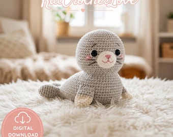 May include: A crocheted gray seal plush toy with a white belly and flippers, and a pink and white face. The toy is lying on a fluffy white surface. The image includes the text "KatCrochetLove" and "Digital Download PDF Pattern".