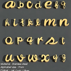Puede incluir: Una colección de dijes con letras minúsculas de color dorado en fuente cursiva. Cada letra está hecha de acero inoxidable y mide 7 mm. El conjunto incluye las letras de la a a la z, cada una con una pequeña anilla para su fijación.