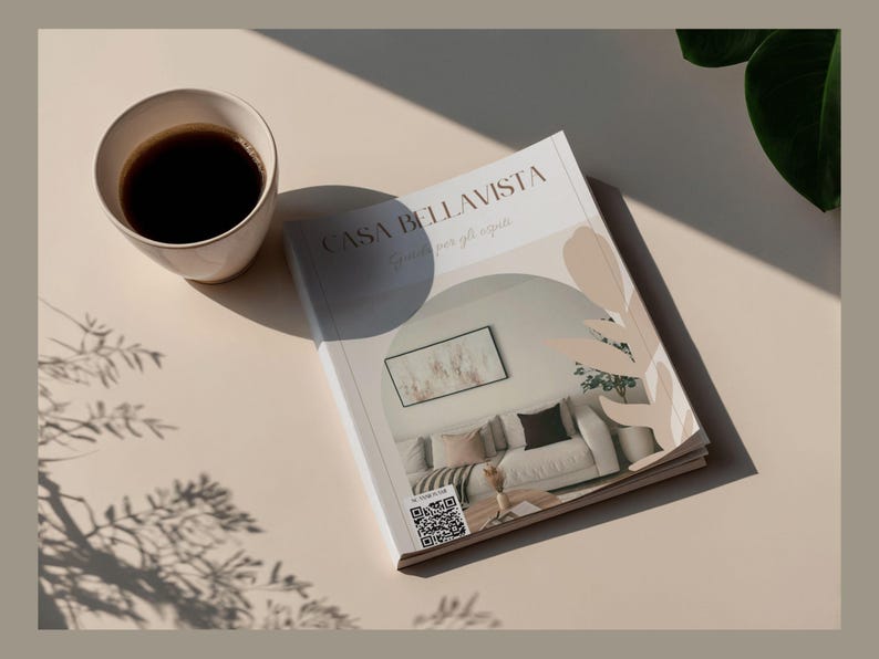 May include: A cup of coffee sits next to a magazine titled "CASA BELLAVISTA" with a QR code. The magazine features a photo of a living room. The scene is set on a beige surface with shadows and a plant.