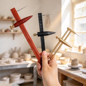 Peut inclure: Trois compas de potier dotés d'une pointe métallique acérée sur le dessus et d'un manche pointu. Un compas est en bois brun rougeâtre, un est noir avec des graduations visibles, et un est en métal doré poli.