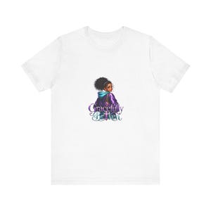 Può includere: T-shirt bianca con un'illustrazione colorata di una persona con i capelli scuri con una felpa con cappuccio viola. Il testo "Gracefully Britten" è sotto in un carattere stilizzato.