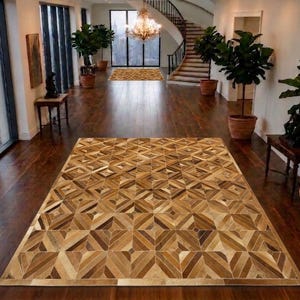 Puede incluir: Una alfombra rectangular grande con un patrón geométrico de patchwork compuesto por piezas de cuero en varios tonos de marrón, beige y crema. La alfombra muestra un diseño repetitivo de rombos y cuadrados en toda su superficie.