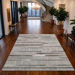 Alfombra de cuero con pelo plateado y gris con estampado de rayas de lana, 152 x 244 cm, hecha a mano.