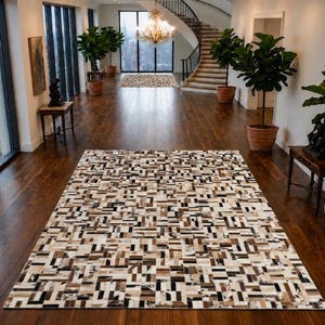 Könnte beinhalten: Ein rechteckiger Teppich mit einem geometrischen Patchwork-Design, das aus kleinen, rechteckigen Fliesen in verschiedenen Nuancen von Creme, Beige, Braun, Schwarz und Weiß besteht und ein komplexes, mehrfarbiges Mosaikmuster auf der gesamten Fläche bildet.