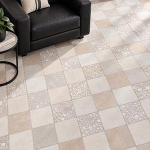 May include: A square-patterned area rug constructed from individual patches of hide in shades of beige, cream, and light gray. The rug features a repeating grid design with alternating solid and speckled textures, stitched together with visible seams.