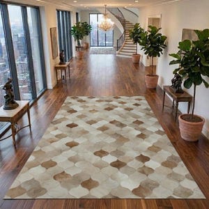 Könnte beinhalten: Ein rechteckiger Teppich mit einem sich wiederholenden, marokkanisch inspirierten Vierpassmuster in Creme-, Beige- und Hellbrauntönen. Der Teppich besteht aus zusammengenähten Fellstücken, die eine strukturierte Oberfläche auf einem Holzboden bilden.