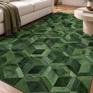 May include: A rectangular area rug featuring a geometric pattern of interlocking cubes in various shades of deep forest green and emerald green. The rug is constructed from stitched panels of textured material with a short, dense pile surface.