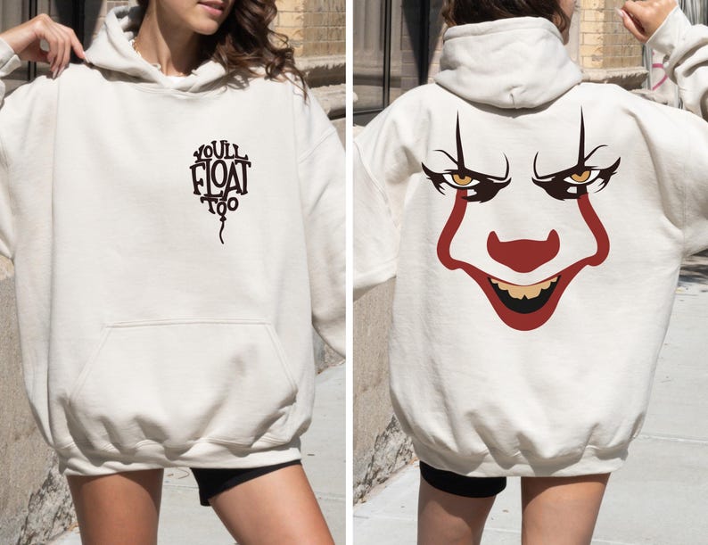 May include: An off-white hooded sweatshirt featuring a black graphic on the front chest that reads "YOU'LL FLOAT TOO" in a balloon shape. The back of the hoodie displays a large, detailed illustration of a clown face with red and black accents.