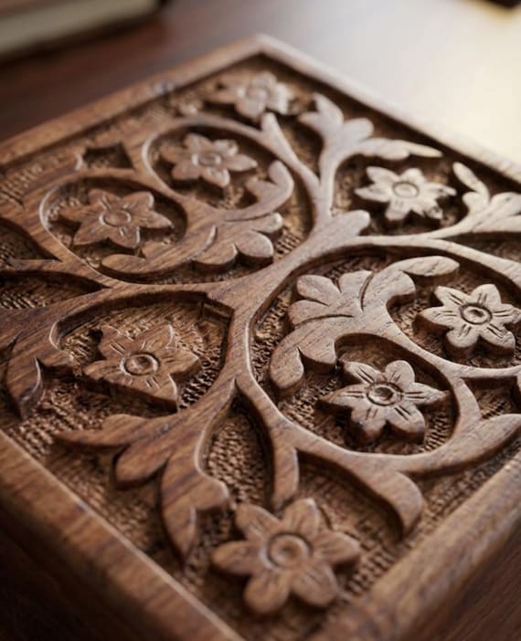 A hand-carved wooden puzzle box with a secret lock mechanism — you have to solve it to get inside, Tree of Life motif and all.