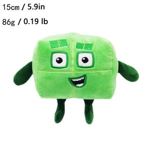 K&ouml;nnte beinhalten: Ein gr&uuml;nes Pl&uuml;schtier in W&uuml;rfelform mit einem l&auml;chelnden Gesicht, Augen, Armen und Beinen. Das Spielzeug ist 15 cm hoch und wiegt 86 g. Das Spielzeug hat ein gen&auml;htes Design und besteht aus weichem Material.