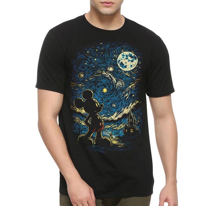 May include: A black short-sleeved t-shirt featuring a graphic print of a silhouette of Mickey Mouse standing in front of a swirling, starry night sky with a large moon and a dark building, rendered in shades of blue, yellow, and white.