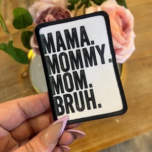 May include: White patch with black text that reads "Mama. Mommy. Mom.  Bruh."